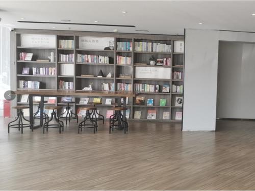 a library with a table and chairs in front of book shelves at Hanting Hotel Tieling Changtu Railway Station in Changtu
