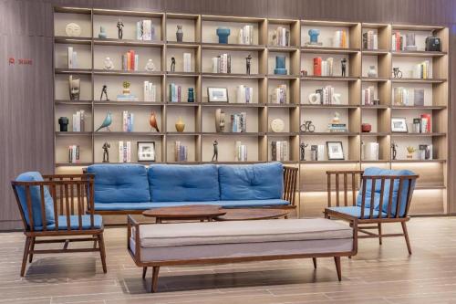 un soggiorno con divano blu e 2 sedie di Hanting Hotel Jiaozuo Wuzhi Yingbin Avenue a Wuzhi