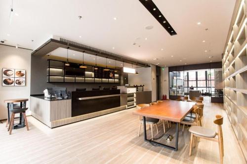 a kitchen and dining room with a wooden table at Hanting Hotel Shanghai Qingpu Huijin Road Metro Station in Qingpu