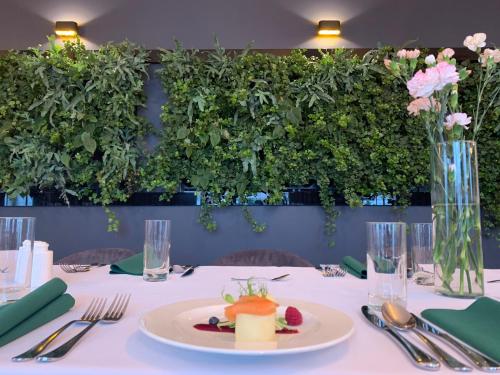 a table with a white table cloth with a plate of food at Hotel Mazovia Airport Modlin in Nowy Dwór Mazowiecki