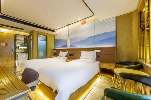 a hotel room with a bed and chairs at Hanting Premium Hotel Shanghai Stadium Metro Station in Shanghai