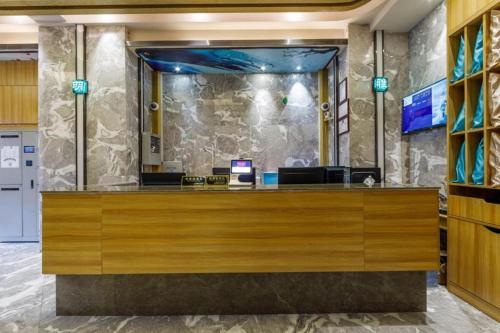 a lobby with a reception desk with a fish tank at Hanting Premium Hotel Shanghai Stadium Metro Station in Shanghai