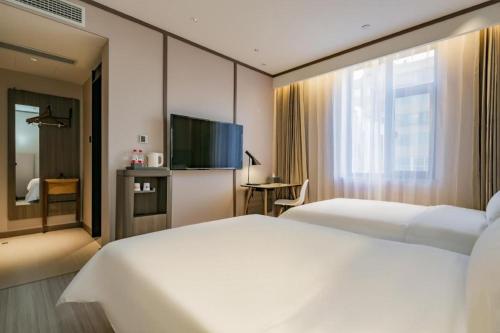 Ein Bett oder Betten in einem Zimmer der Unterkunft Hanting Hotel Kashgar Tumushuk
