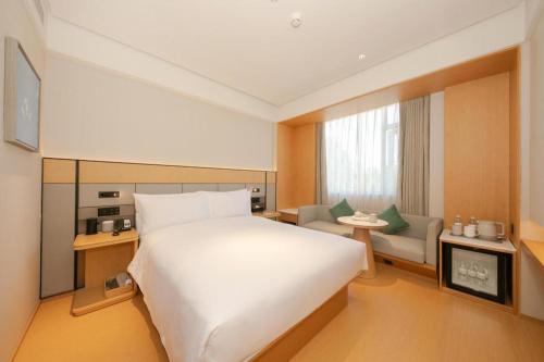 Un pat sau paturi într-o cameră la Ji Hotel Beijing Shijing Mountain Wanda Taiwan Street