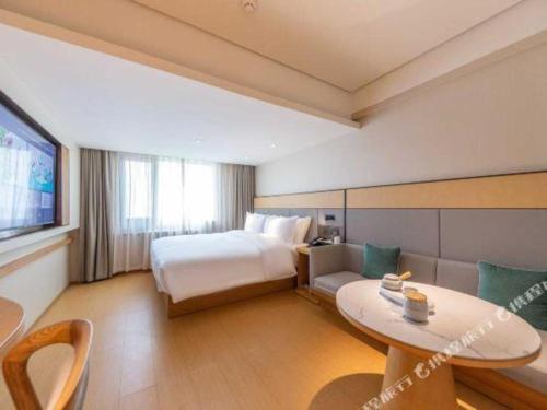 a hotel room with a bed and a table at JI Hotel Lanzhou University Donggang West Road in Baidaoping