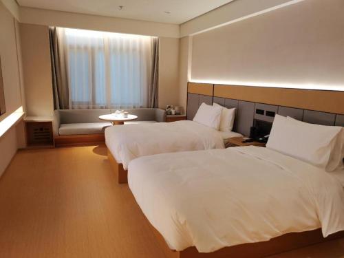 Un pat sau paturi într-o cameră la Ji Hotel Jinzhou Red Star Macalline