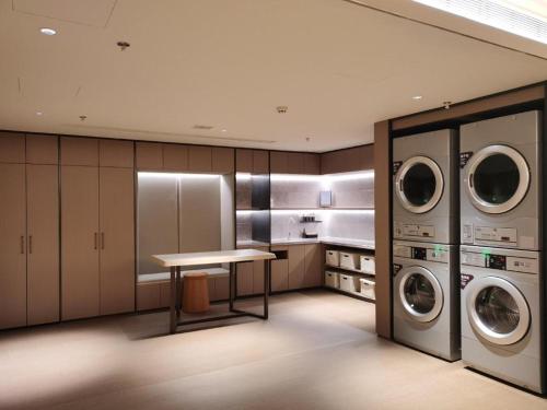 a laundry room with a table and two machines at Ji Hotel Jinzhou Red Star Macalline in Jinzhou