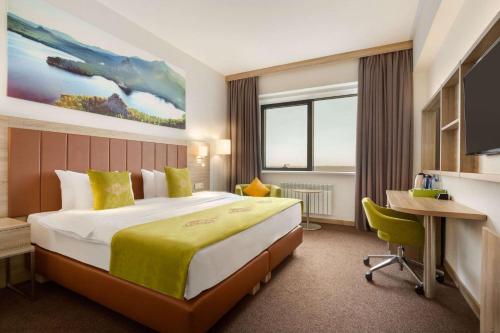 A bed or beds in a room at Wyndham Garden Astana