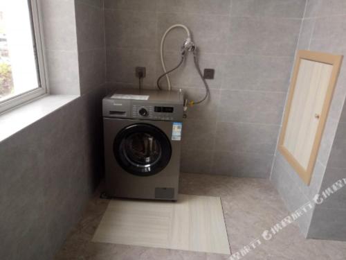 a washing machine in a bathroom with a window at Hi Inn Xining Mojia Street in Xining