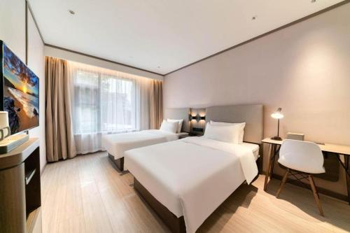 Een bed of bedden in een kamer bij Hanting Hotel Hangzhou Binjiang Xingguang Avenue