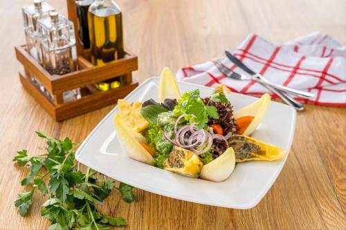 a plate of food with a salad on a table at Hotel Schwarzwald Freudenstadt in Freudenstadt