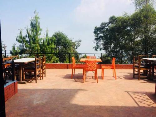 un patio con mesas, sillas y una mesa. en Hotel Elephant Nagarkot en Nagarkot