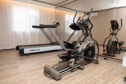 a gym with two exercise bikes and a treadmill at Hanting Hotel Cixian Yizhong in Cizhou