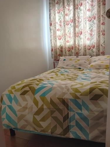 ein Bett mit farbenfroher Bettdecke in einem Schlafzimmer in der Unterkunft Condotel 2 bedroom with terrace and free car parking in Naga