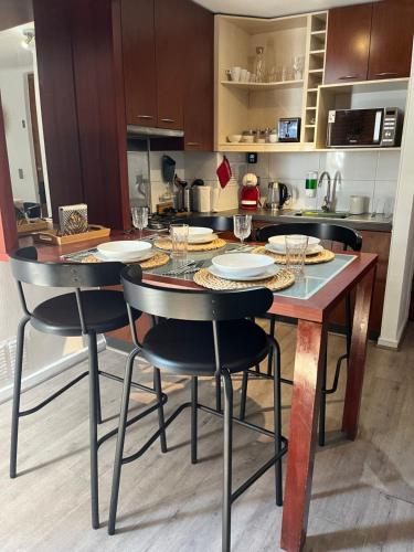 a kitchen with a table with chairs and glasses at NR apart in Santiago