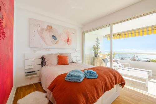 une chambre avec un lit et une grande fenêtre dans l'établissement Appartement Marina Baie des Anges, à Villeneuve-Loubet