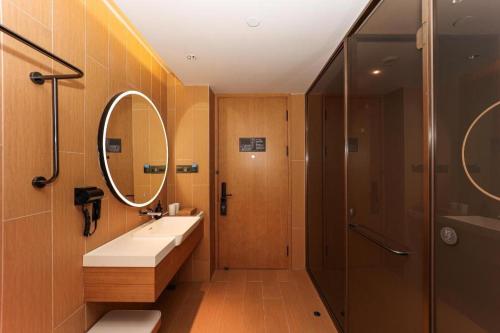 a bathroom with a sink and a shower at Ji Hotel Shanghai Xujiahui Guanshengyuan Road in Shanghai