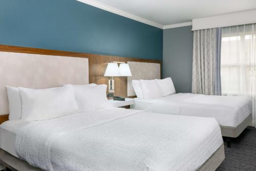 two beds in a hotel room with blue walls at Hampton Inn Savannah Historic District in Savannah