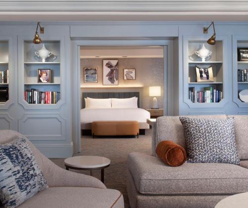 a hotel room with a bed and a couch and chairs at Hilton Anatole in Dallas