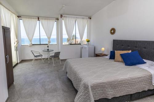 Un dormitorio con una cama grande y una mesa con sillas. en Albamar - Casa Antonio - Beach house, en El Ñuro