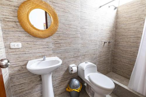 y baño con lavabo, aseo y espejo. en Albamar - Casa Antonio - Beach house, en El Ñuro