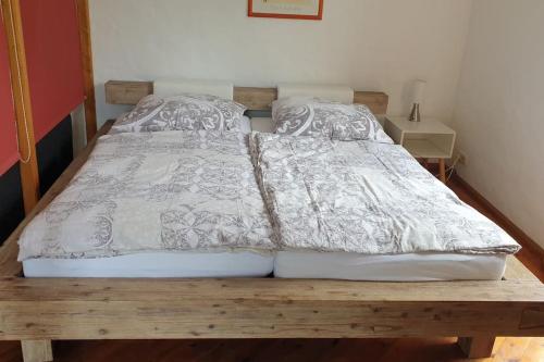 a bed with a white comforter on a wooden bench at Fewo mit eigener Terrasse und Ausblick in Mechernich