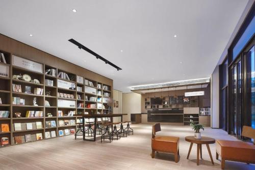 a library with chairs and tables and bookshelves at Hanting Hotel Nanjing Xianlin Hongfeng Science and Technology Park in Shifo'an