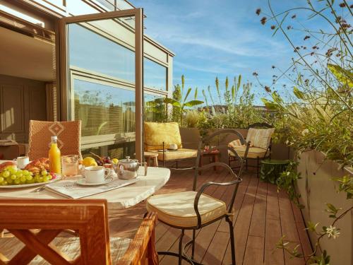 een patio met een tafel en stoelen op een balkon bij Mondrian Bordeaux Les Carmes in Bordeaux