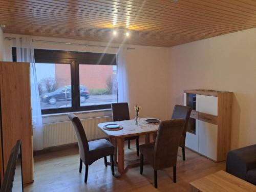 uma sala de jantar com uma mesa e cadeiras e uma janela em Zentrale 3-Zimmer-Ferienwohnung em Ilmenau
