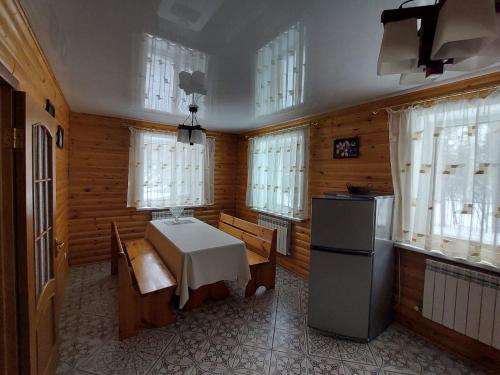 a kitchen with a table and chairs and windows at Krona Borovoe in Barmashino