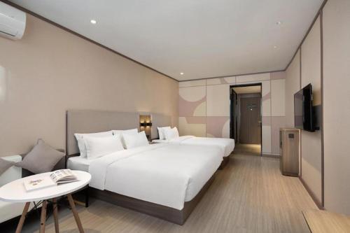 Łóżko lub łóżka w pokoju w obiekcie Hanting Hotel Changsha Railway Station Metro Station