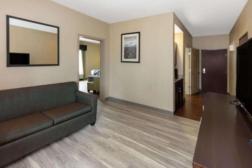 a living room with a couch and a television at La Quinta Inn & Suites by Wyndham Durant in Durant