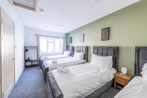 a bedroom with three beds with white sheets at Newly Refurbished Upnor House with 2 Free Parking by Prescott Apartments in Bristol