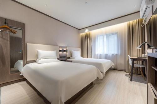 Un pat sau paturi într-o cameră la Hanting Hotel Shanghai Xujiahui Yishan Road