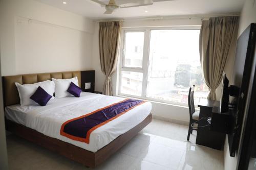 a bedroom with a bed and a large window at Balaji gold inn hotel in Hubli