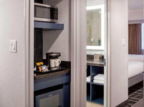 a room with a bed and a kitchen with a microwave at Doubletree Suites by Hilton Salt Lake City in Salt Lake City