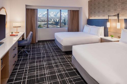 a hotel room with two beds and a television at Doubletree Suites by Hilton Salt Lake City in Salt Lake City