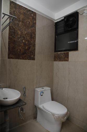 łazienka z toaletą i umywalką w obiekcie Balaji gold inn hotel w mieście Hubballi-Dharwar