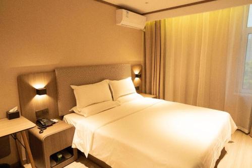 Łóżko lub łóżka w pokoju w obiekcie Hanting Hotel Handan Century Street