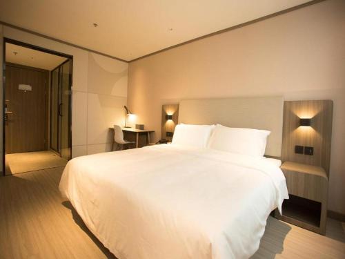 Un ou plusieurs lits dans un hébergement de l'établissement Hanting Hotel Jining Tangkou Airport