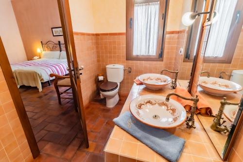 een badkamer met 2 wastafels en een toilet bij Hotel Rural La Sinforosa in Alange