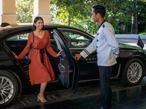 un hombre y una mujer entrando en un coche en Sofitel Phnom Penh Phokeethra en Phnom Penh