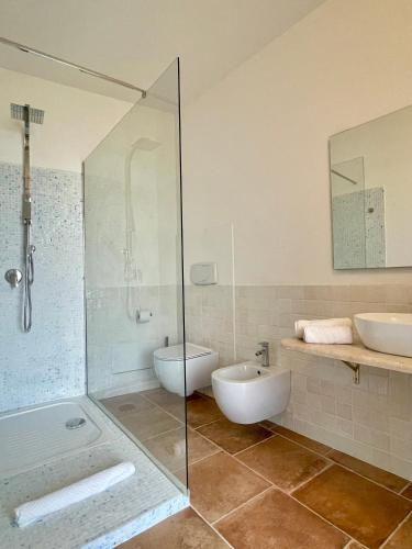 a bathroom with a shower and a toilet and a sink at Domu Su Neulaghe in Villasimius