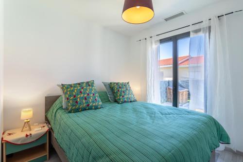 een slaapkamer met een bed en een groot raam bij Rascola villa piscine 4 étoiles in Le Boulou