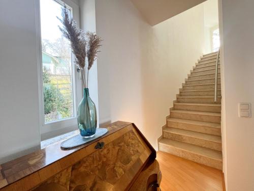 a vase sitting on a dresser in a room with stairs at LIBORIA I Villa mit Seeblick 10min vom See in Herrsching am Ammersee