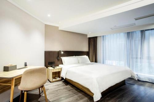 Säng eller sängar i ett rum på Hanting Premium Hotel Shanghai Zhongshan Park Yan'an Road