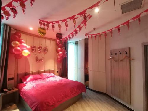 1 dormitorio con cama rosa y globos en el techo en Hi Inn Kaifeng Xiaosongcheng, en Kaifeng