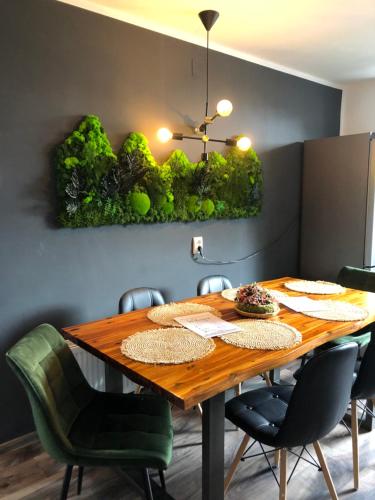 a dining room with a wooden table and chairs at Cityscape Comfort with key lockbox in Sfântu-Gheorghe