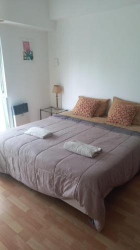 a large bed with two pillows on top of it at Departamento Céntrico Zona Basílica de Luján in Luján