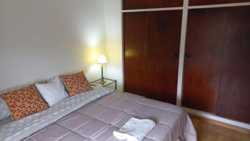 a bedroom with a bed and a wooden door at Departamento Céntrico Zona Basílica de Luján in Luján